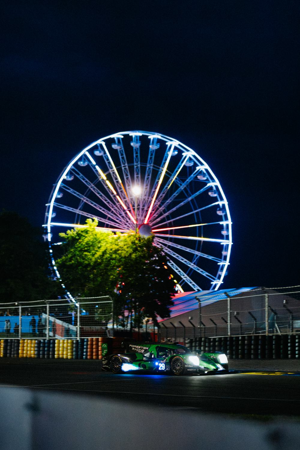 La voiture en piste de nuit devant la grande roue